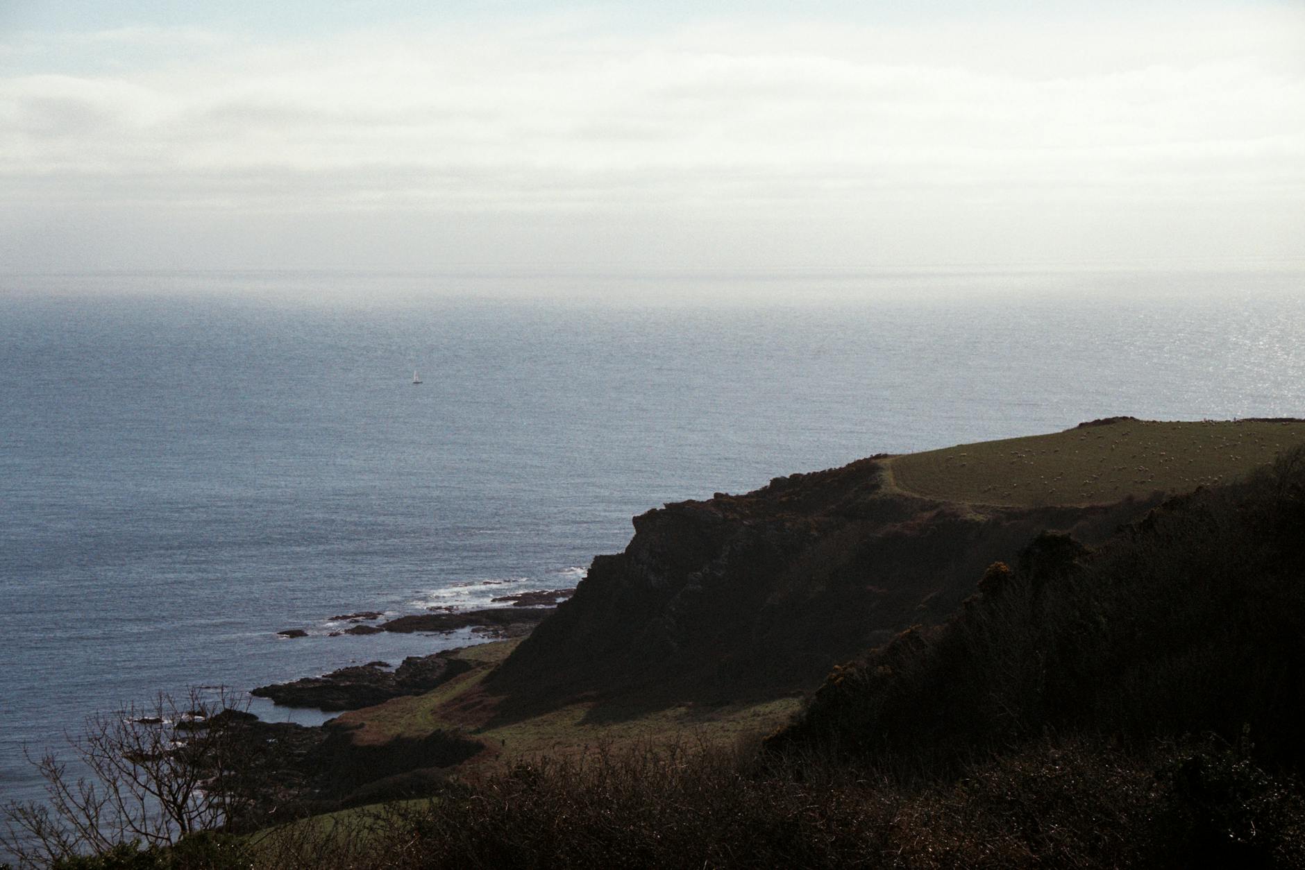 Scenic view of the rugged coastline near Exeter, England, with expansive sea and cliffs.