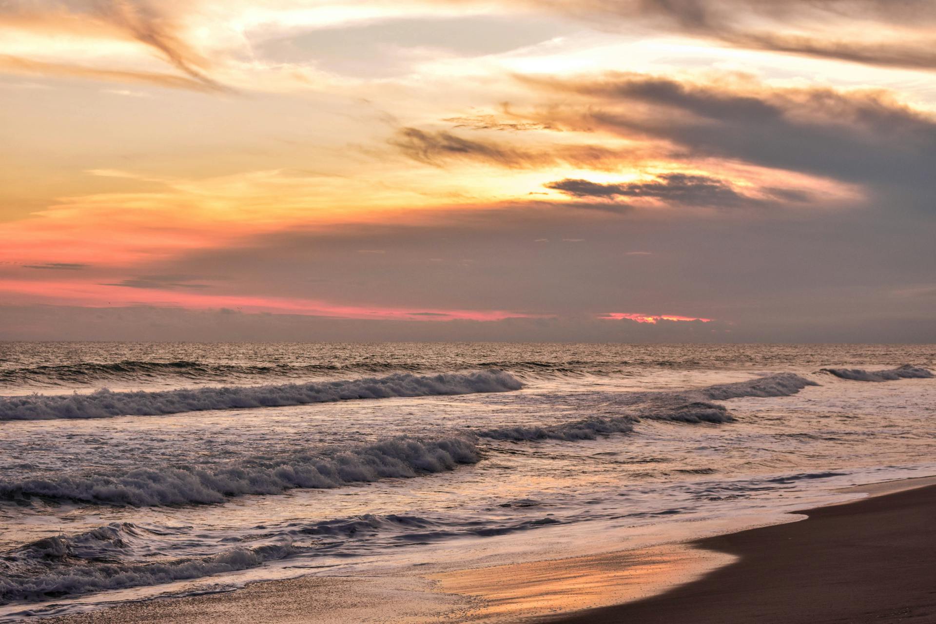 Beautiful sunset at La Libertad Beach in El Salvador, capturing the serene waves and vibrant sky.