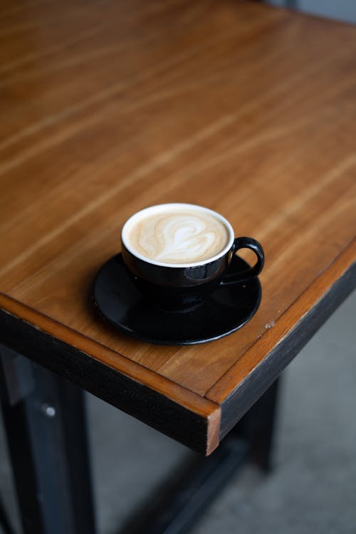 ahşap masa, cappuccino, dikey atış içeren Ücretsiz stok fotoğraf