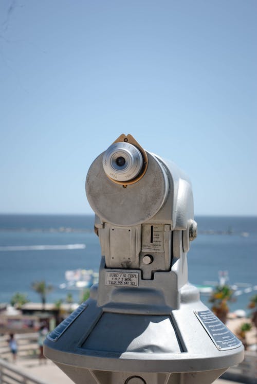 A coin operated binoculars on a post overlooking the ocean