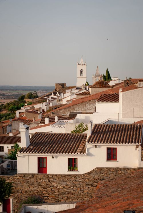 Free A picturesque aerial view of a European village with classic tiled rooftops and white buildings. Stock Photo