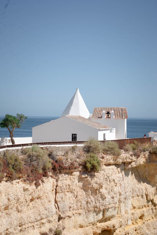 A white church on a cliff overlooking the ocean