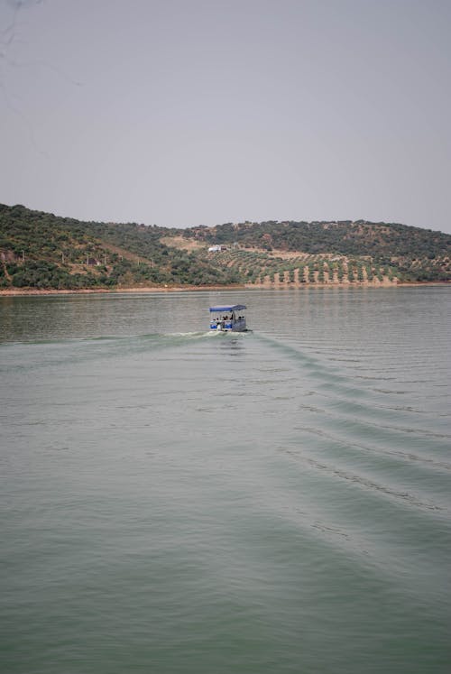 View of a Boat on a Body of Water with Hills in Distance