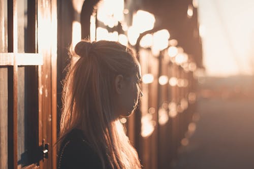 Woman Standing near Building at Sunset