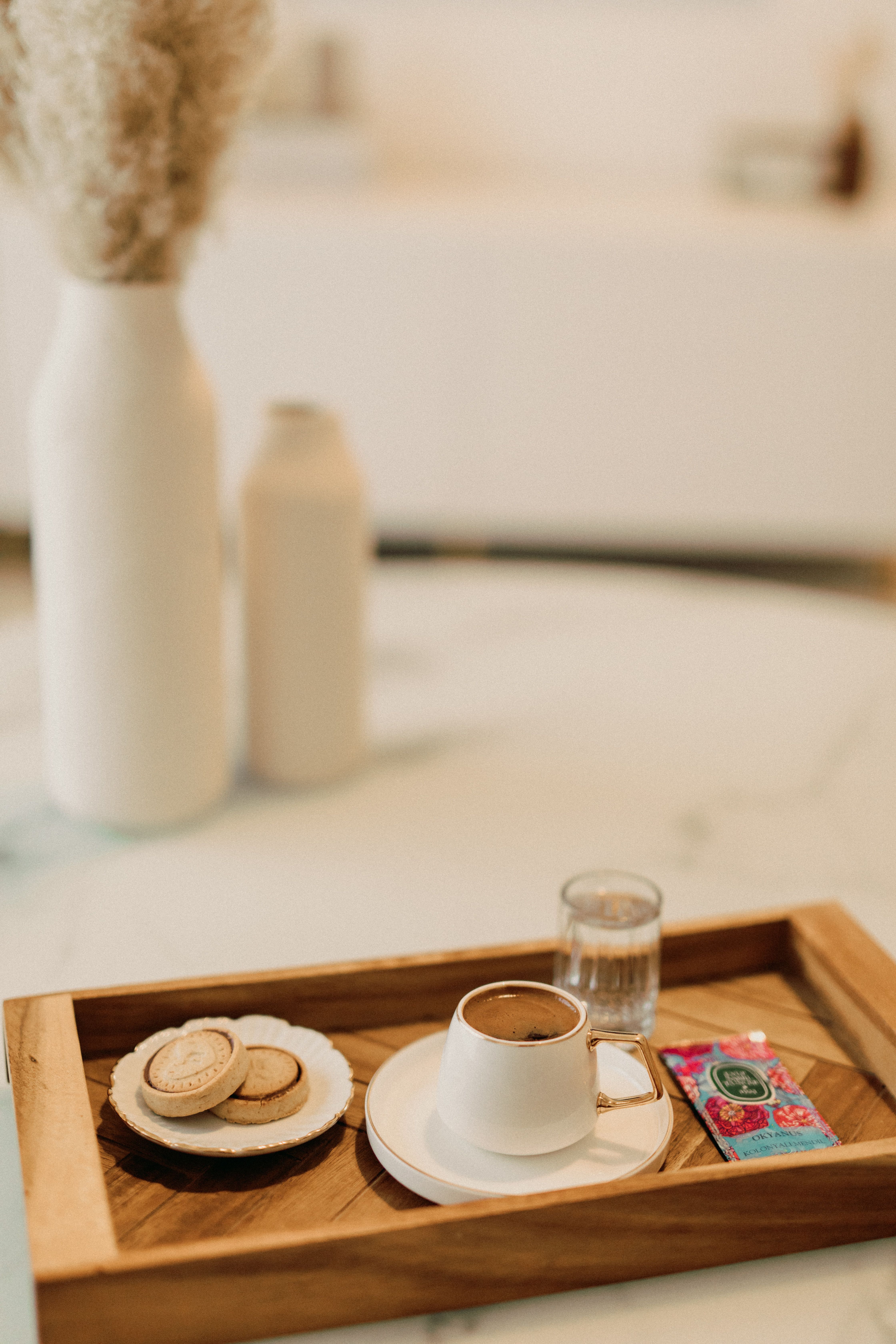light wooden coffee tray holding two mugs and a small creamer pitcher