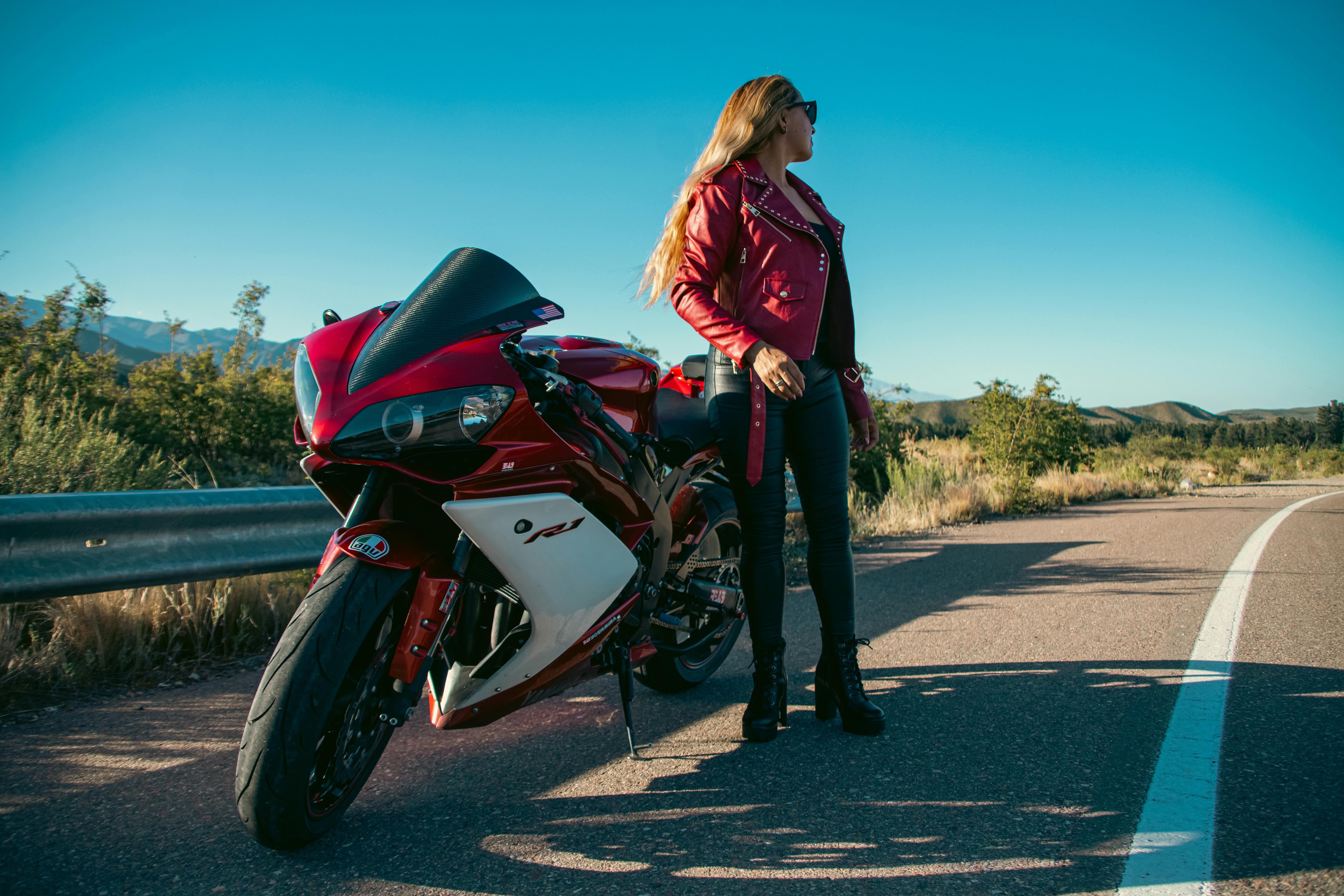Woman In Black Leather Jacket Sitting On Blue And White Suzuki Gsx