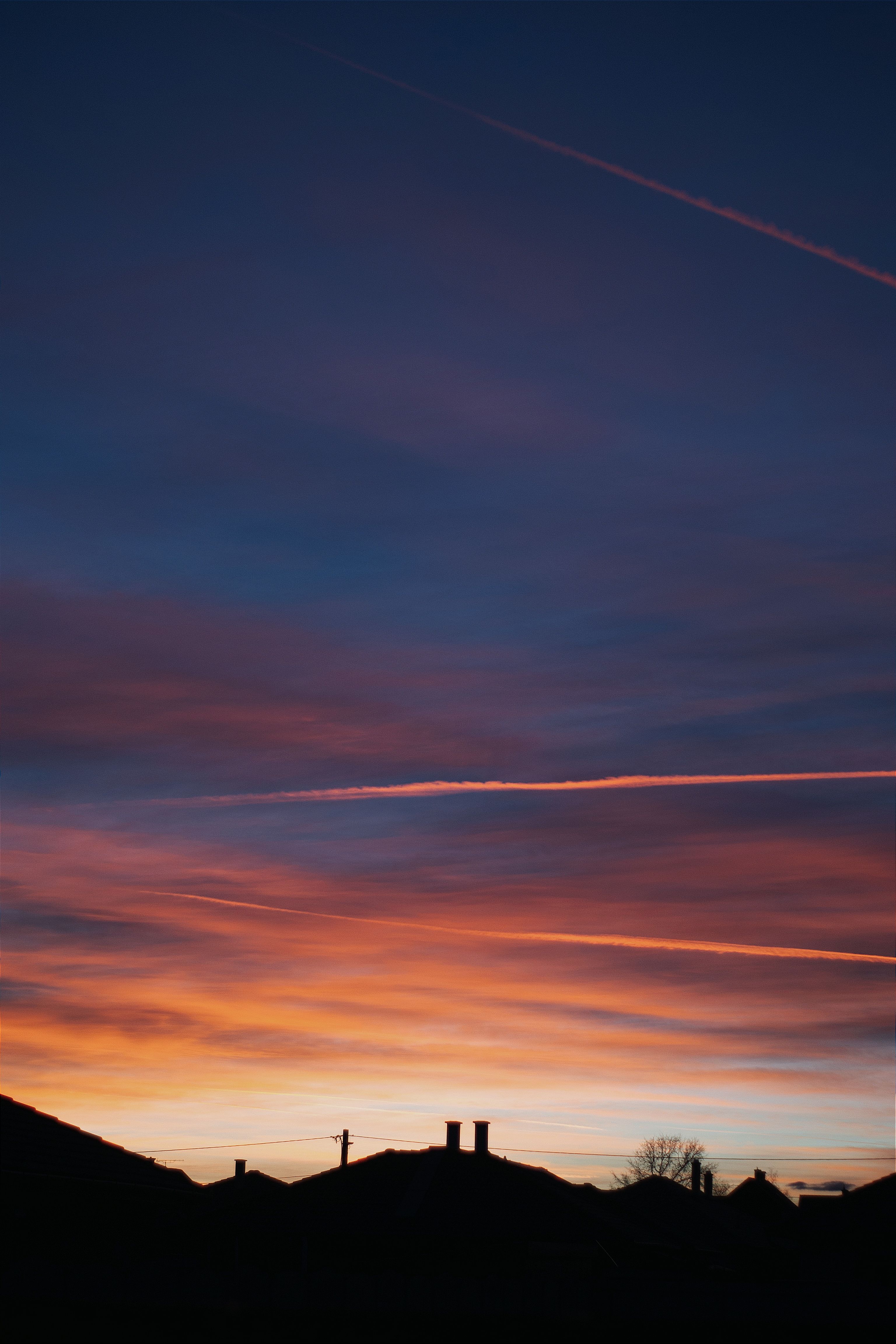 Stunning silhouette of rooftops against a vibrant sunset sky in a rural village in Hungary.