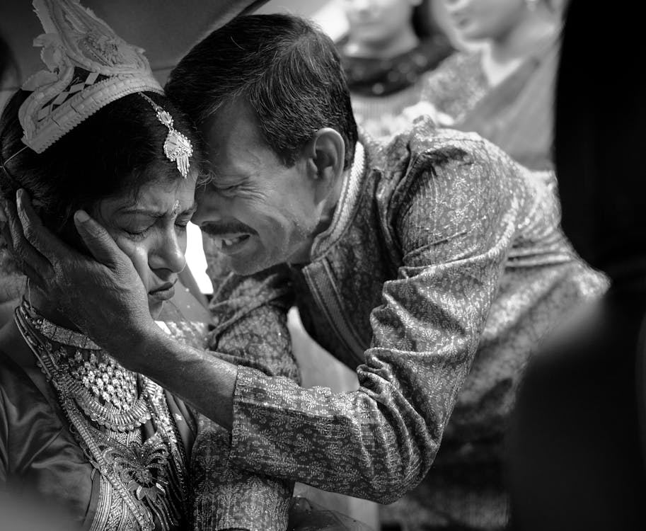 A man is hugging a woman in traditional dress