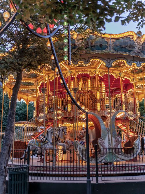 Free Brightly lit carousel in an amusement park, captured at dusk with elegant lights and decorative horses. Stock Photo