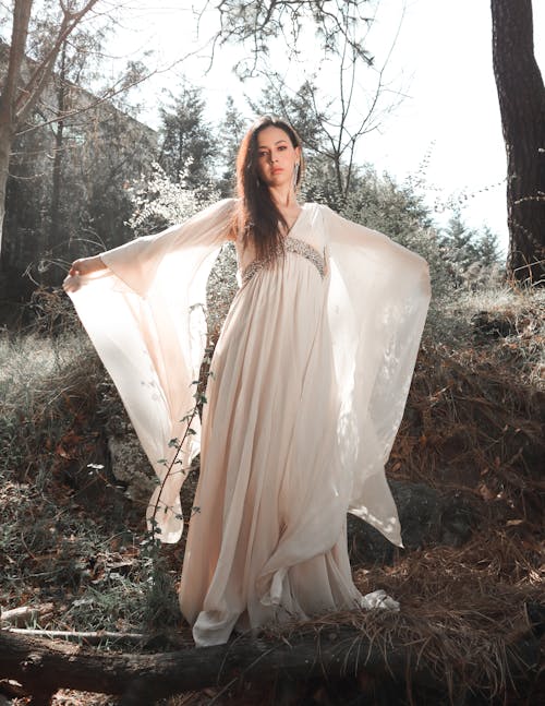 Woman in White Dress Standing among Trees