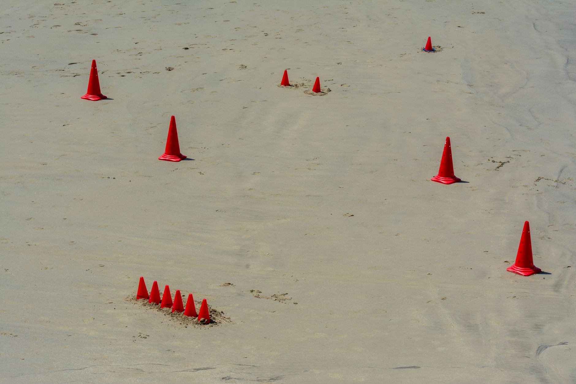 Three training cones arranged across a basketball court while a coach tests an athlete’s vision