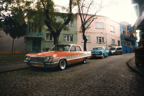 Free Vintage Chevrolet car parked on a cobblestone street in an urban neighborhood. Stock Photo
