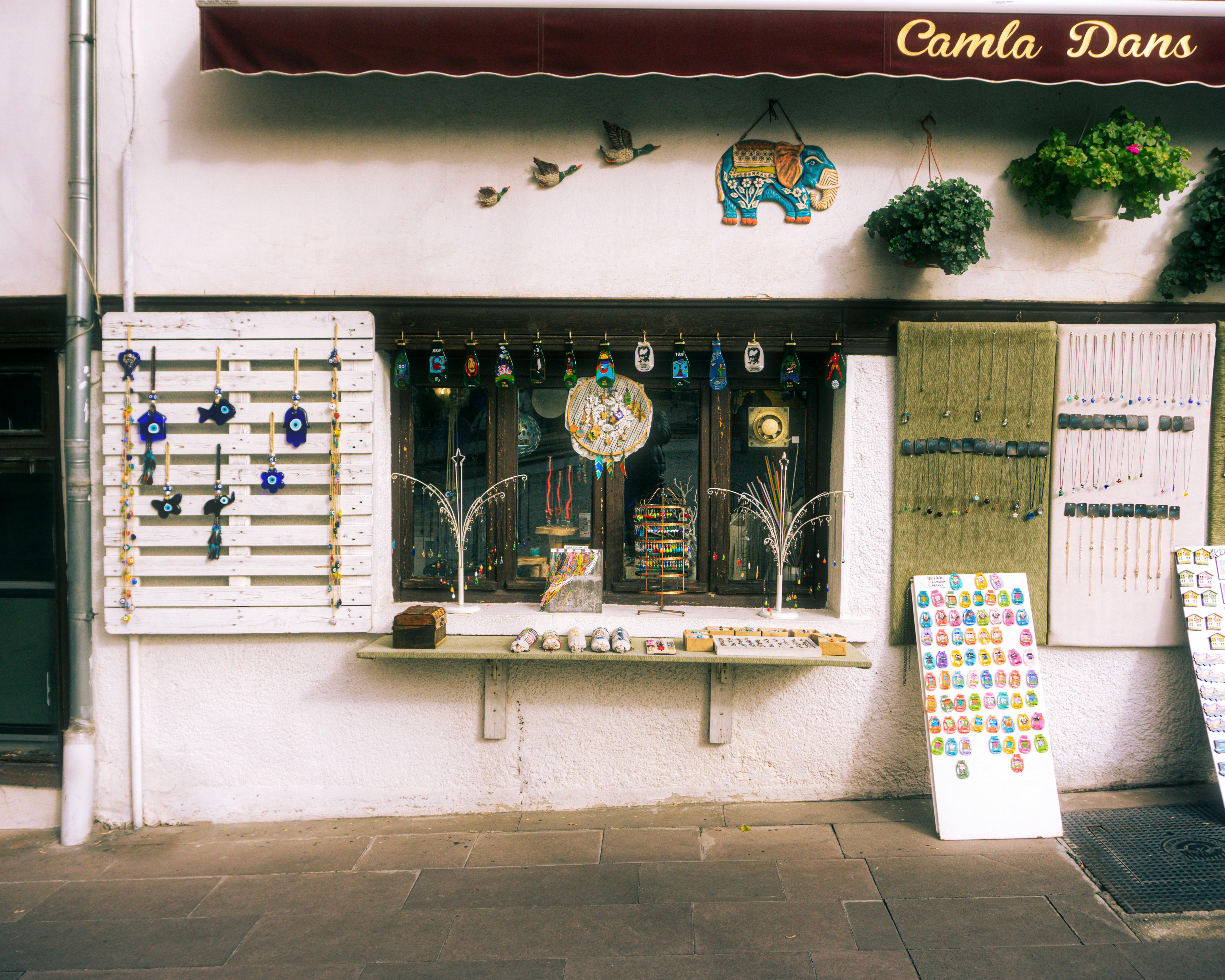 A quaint Turkish gift shop displaying vibrant souvenirs and art on a sunny town street.