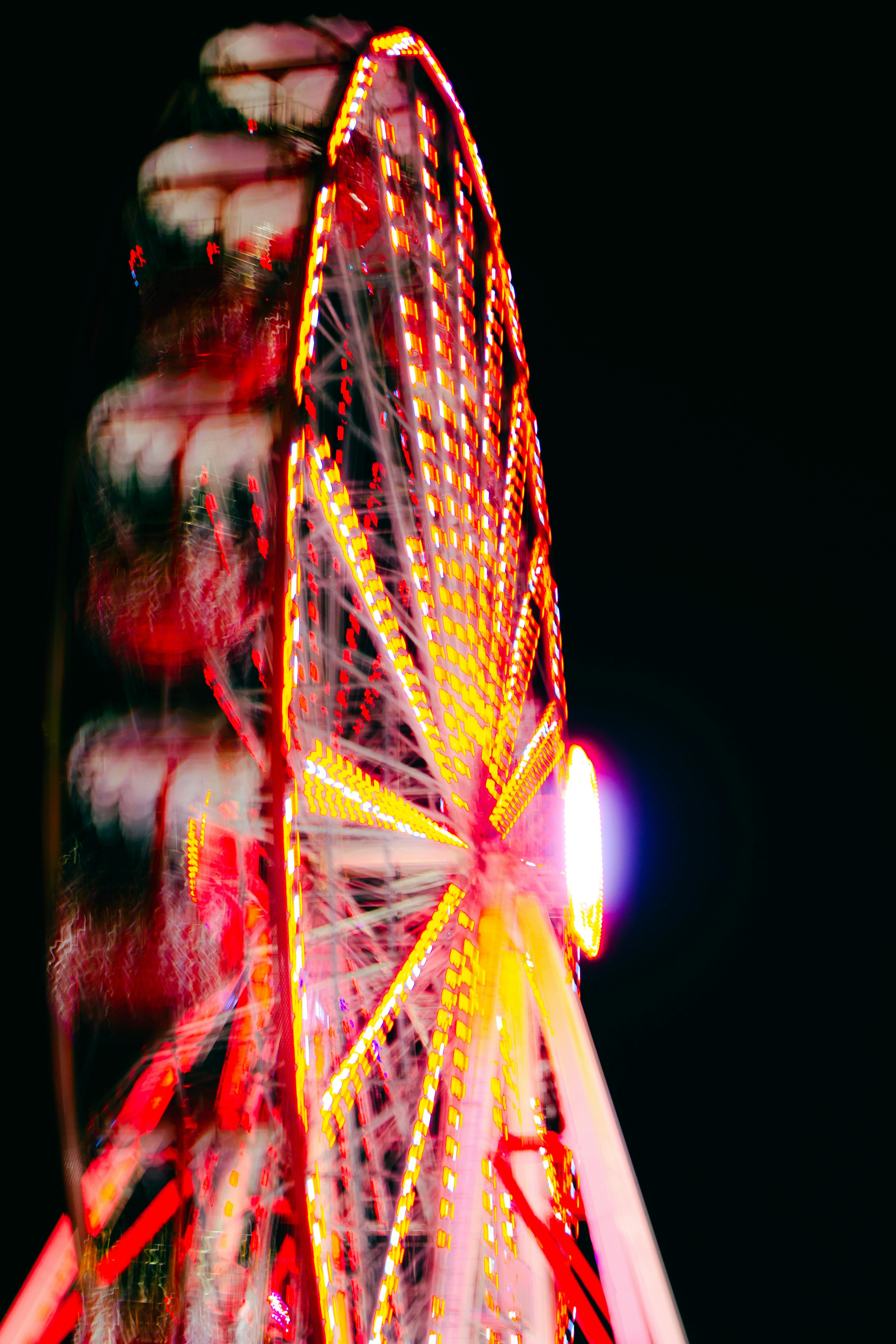 Vibrant illuminated ferris wheel in motion at night.