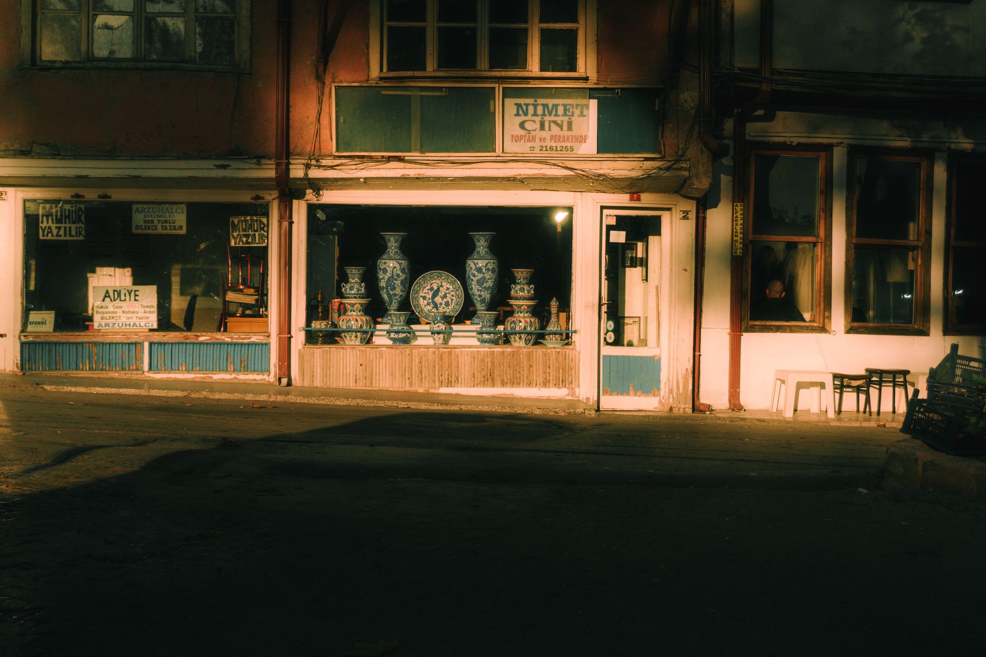 Cozy evening view of a Turkish antique shop with porcelain vases in the window display.