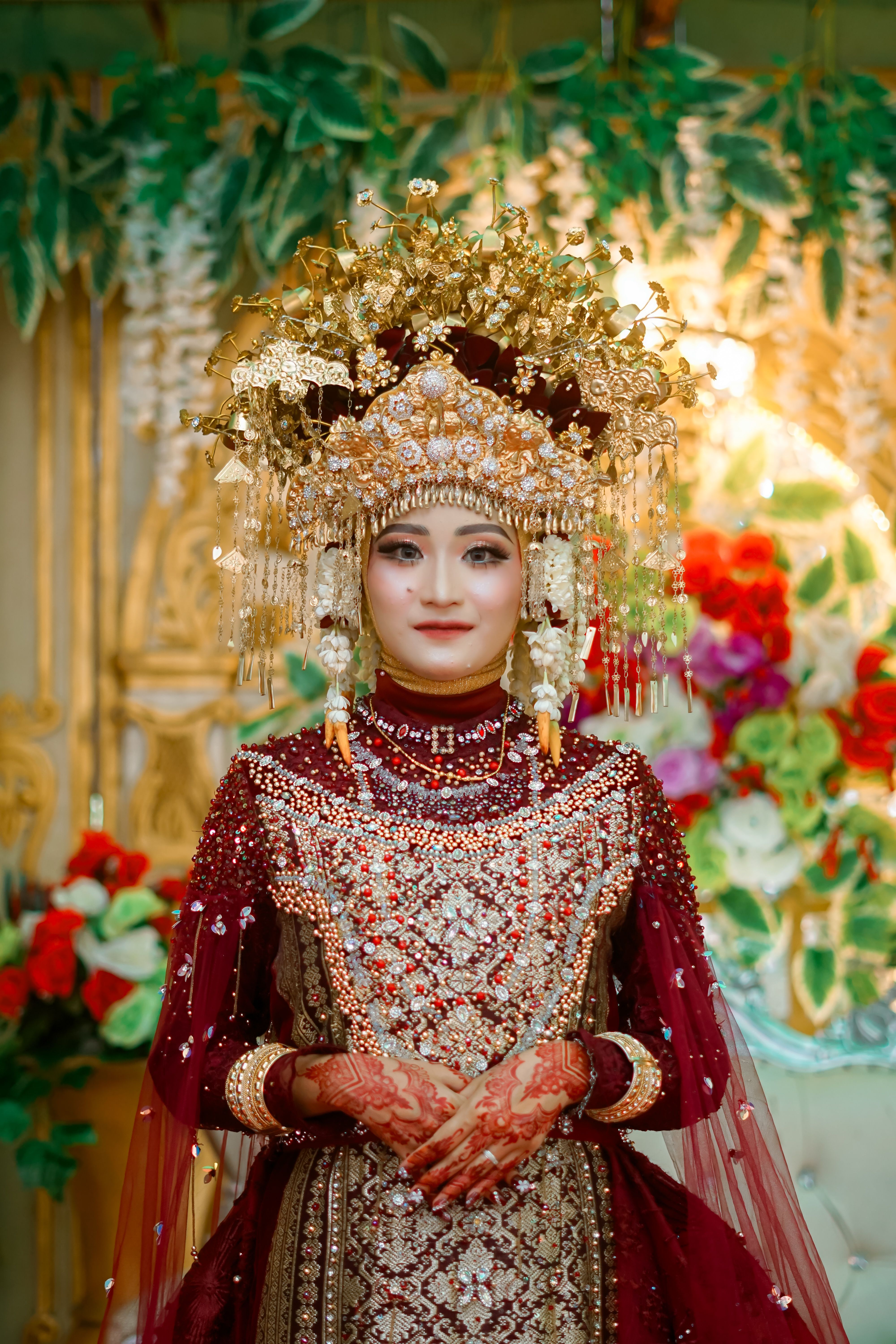 A stunning portrait of a bride in ornate red and gold traditional attire, exuding elegance.