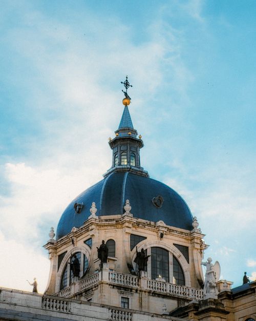 Free Features the striking dome of Almudena Cathedral against a blue sky in Madrid, Spain. Stock Photo