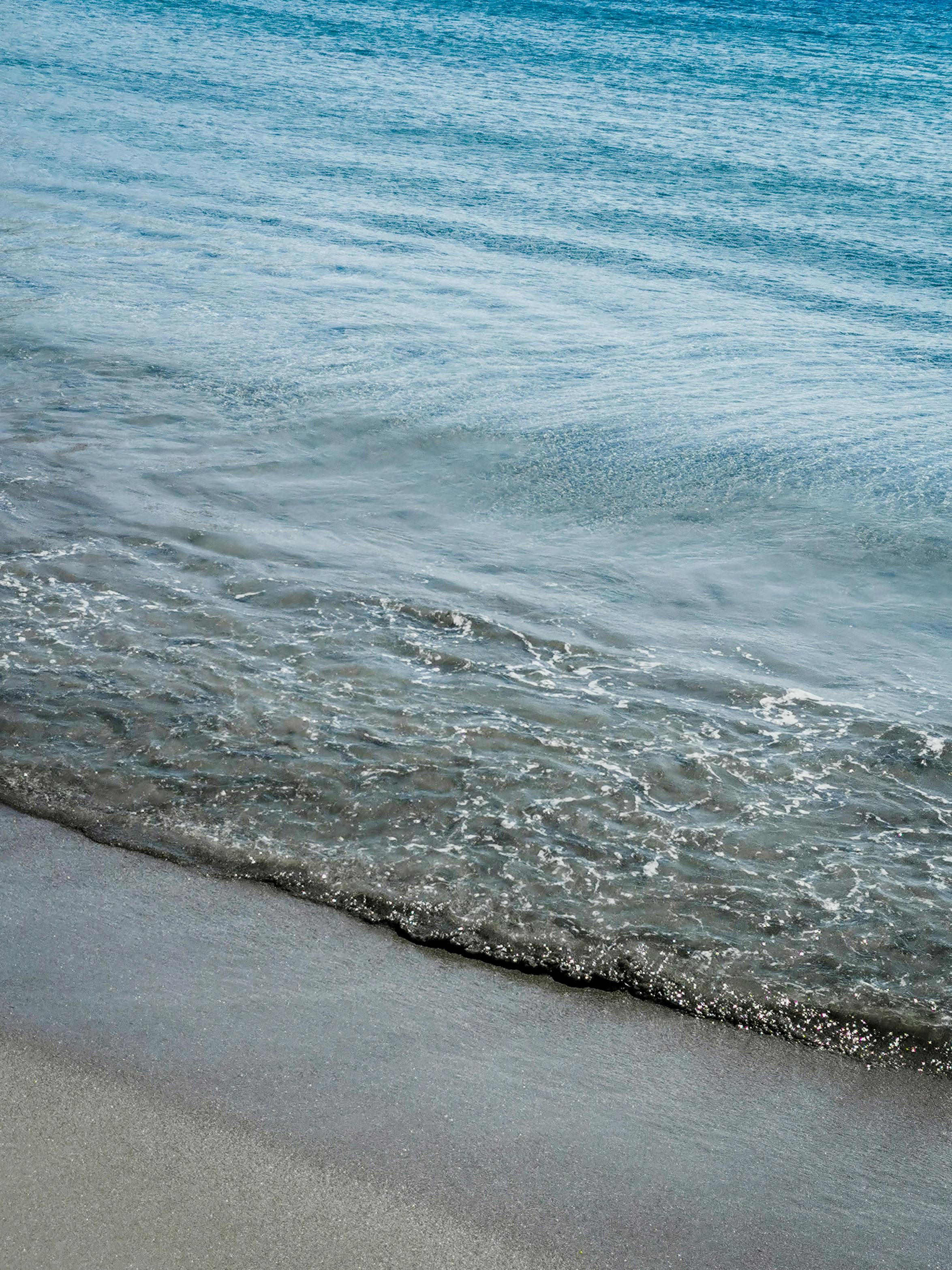 Gentle waves lapping on Antiparos beach, Greece, capturing a serene summer day.