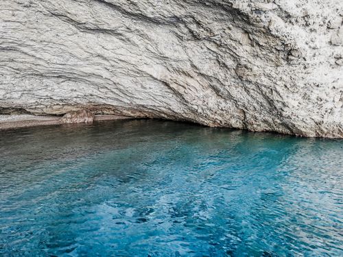 Free Explore the serene sea cave with turquoise waters and rugged rocky cliffs at Antiparos, Greece. Stock Photo
