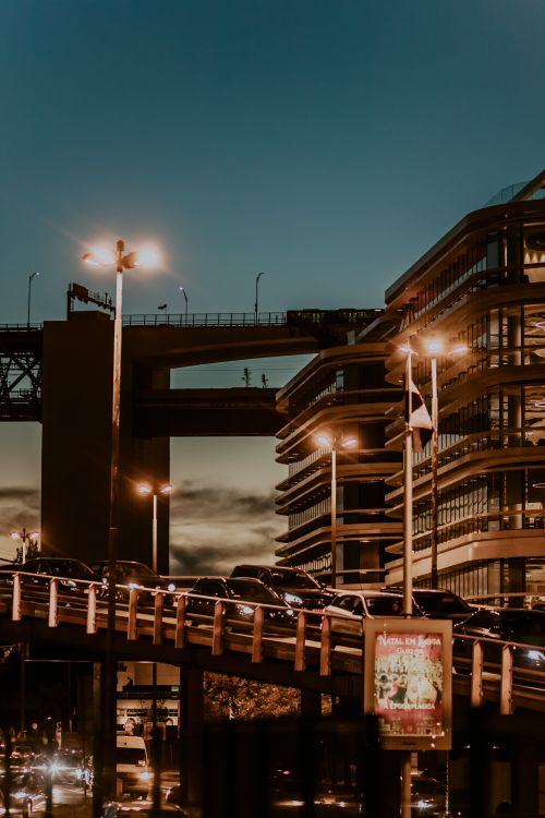Free Traffic jam on illuminated city streets with overpass during dusk. Stock Photo
