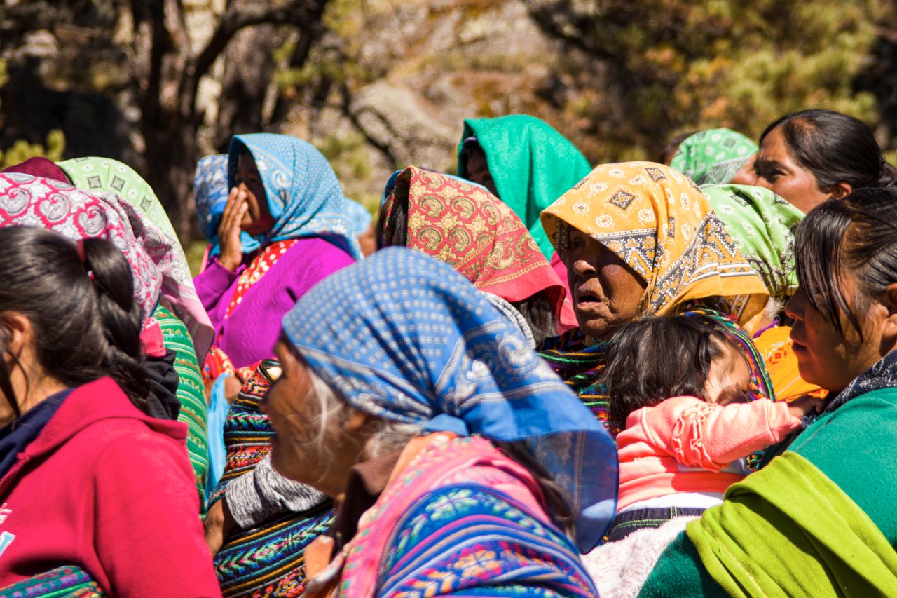 Mujeres indígenas reunidas con vestimenta tradicional colorida.