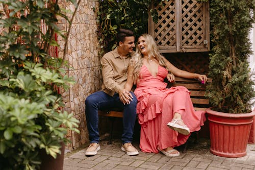 Couple Sitting on Bench and Laughing