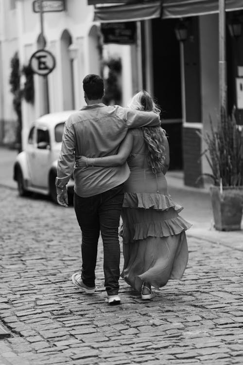 Couple Hugging and Walking on Cobblestone Street in Black and White