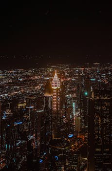 A breathtaking aerial view of a bustling cityscape illuminated at night, showcasing urban architecture and vibrant lights.