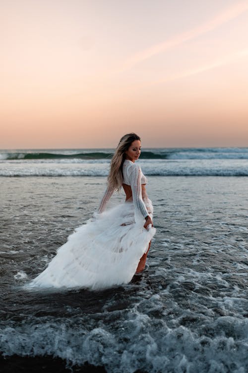 Woman in a White Dress Standing in the Sea