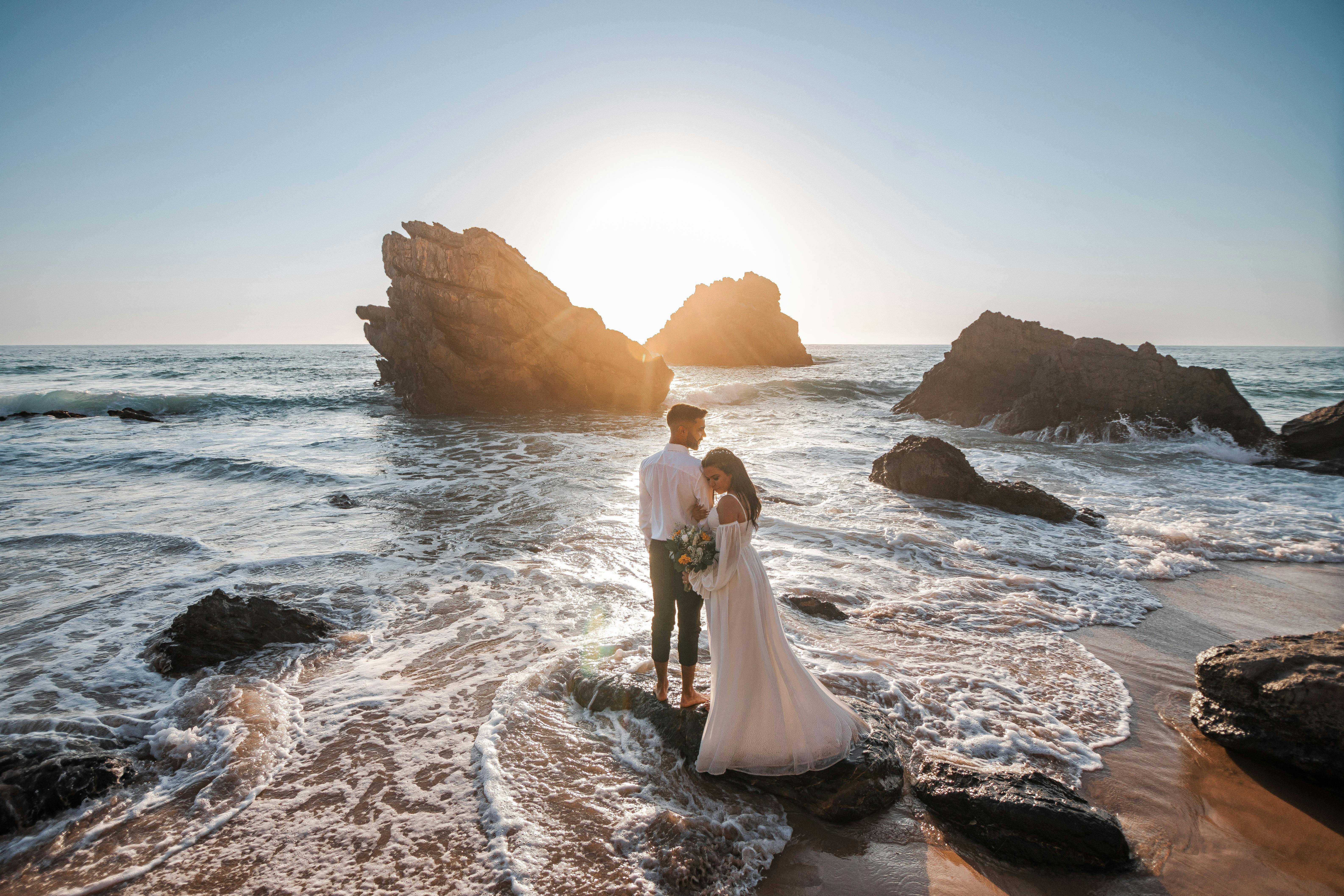 newlyweds embracing at the beach