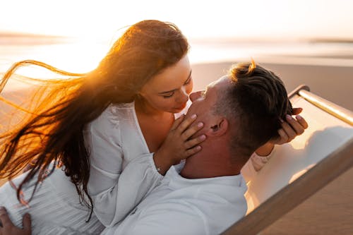 Couple About to Kiss while Lying in a Lounge Chair
