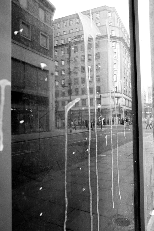 A black and white photo of a window with graffiti