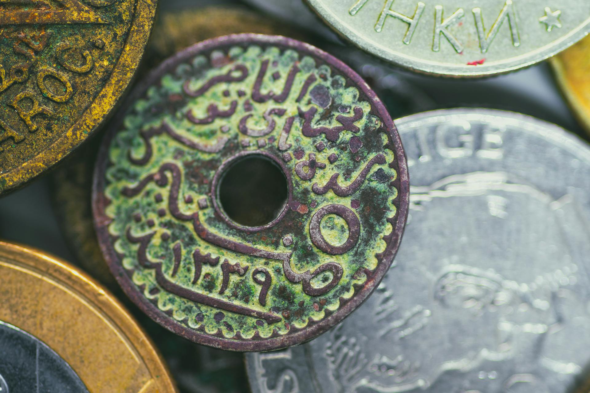 Macro photography of an antique Tunisian coin with Arabic script and intricate details.