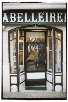 Vintage-style barbershop entrance with reflections in Lisbon, Portugal.