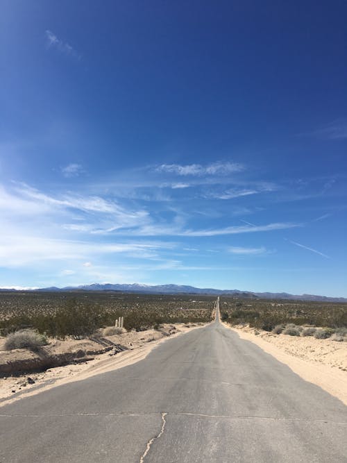 Asphalt Road on a Desert under Blue Sky