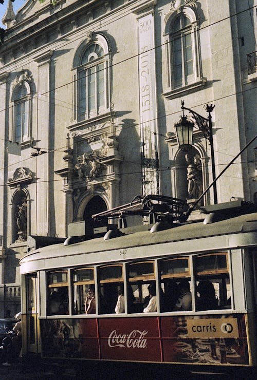 A trolley car is parked in front of a building