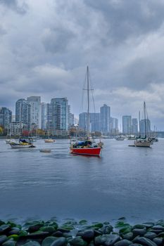 Captivating cityscape of Vancouver with sailboats and skyline on a cloudy day.