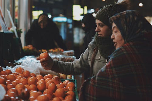 Women Looking at Clementines at Market