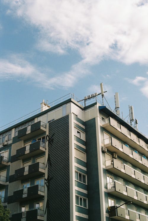 A tall building with a blue sky and clouds