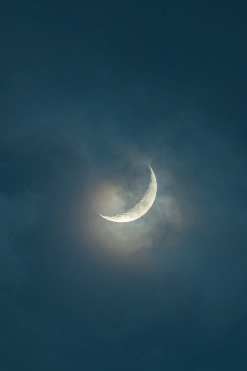 A crescent moon is seen in the sky with clouds