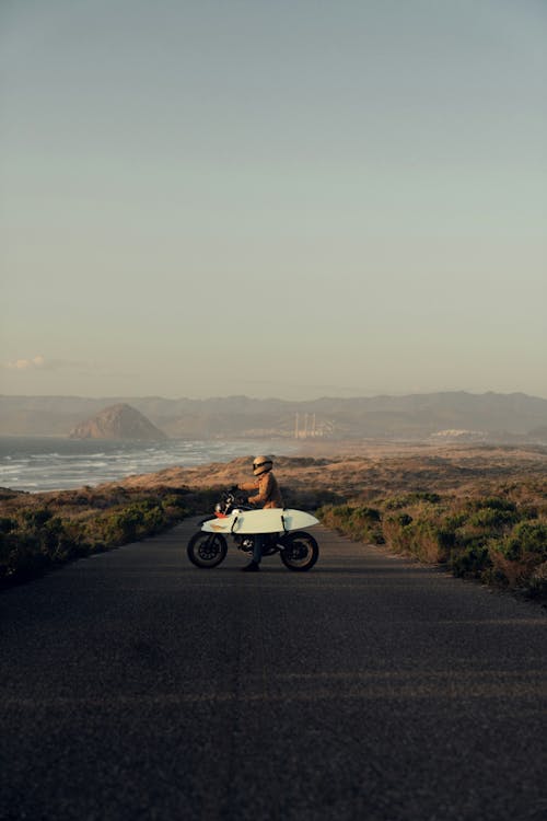Free A person riding a motorcycle on a road Stock Photo