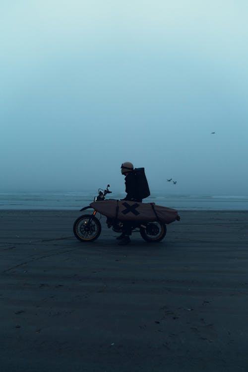 Man on Motorbike on Beach under Fog