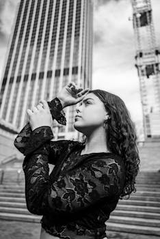 Stylish young woman in a city setting with skyscrapers.