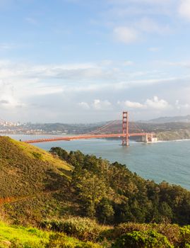 A breathtaking view of the Golden Gate Bridge spanning the San Francisco Bay, framed by lush hills.