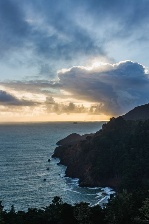 Free Dramatic sunrise at Marin Headlands with rocky cliffs and ocean waves. Perfect travel destination view. Stock Photo