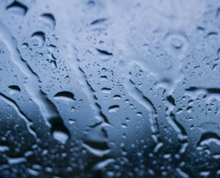 Close-up view of water droplets on a glass surface, creating an abstract pattern.