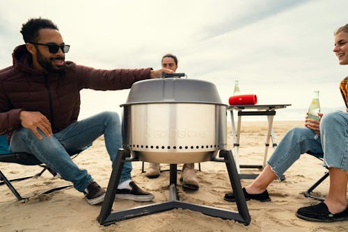 A group of people sitting around a portable grill