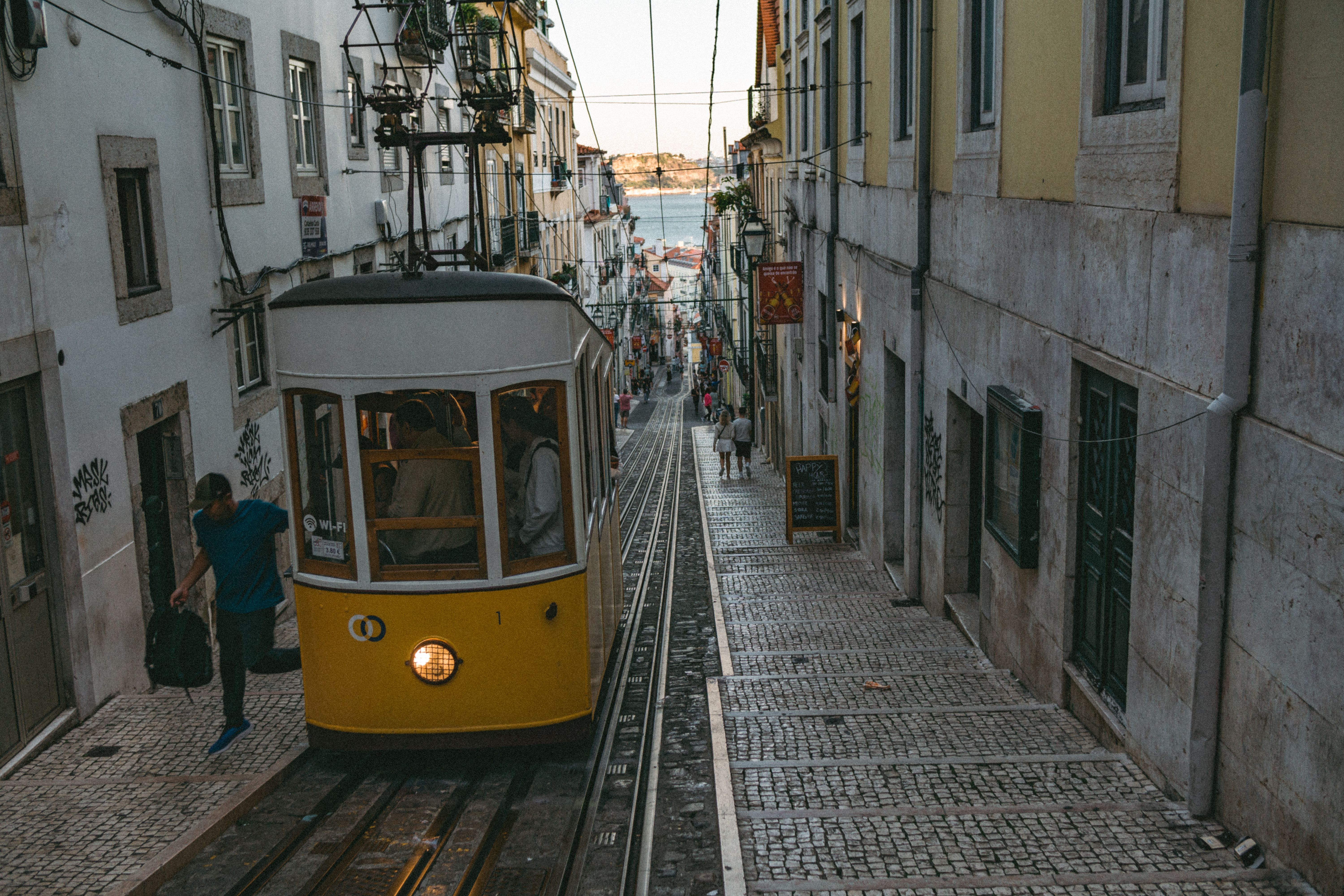 alfama district lisbon tram yellow cobblestone viewpoint