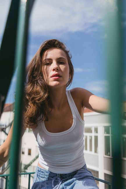 Stylish young woman in casual attire posing outdoors in Lisbon, Portugal.