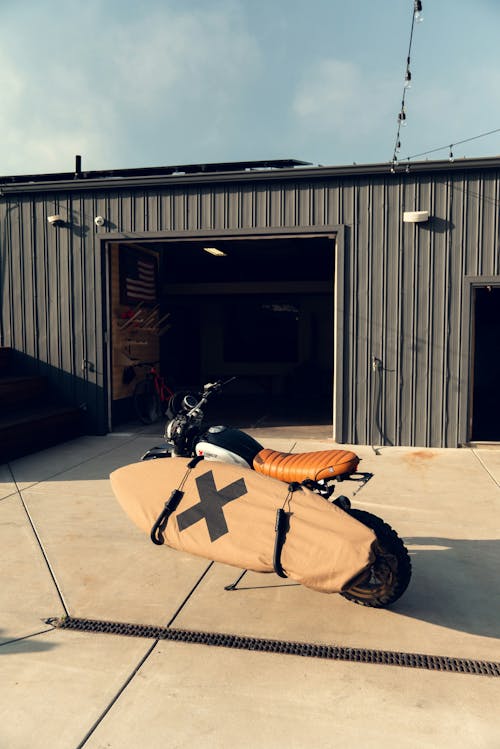 A motorcycle with a surfboard strapped to it